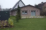 FeWo Smilla Man blickt über eine Rasenfläche auf das kleine Ferienhäuschen